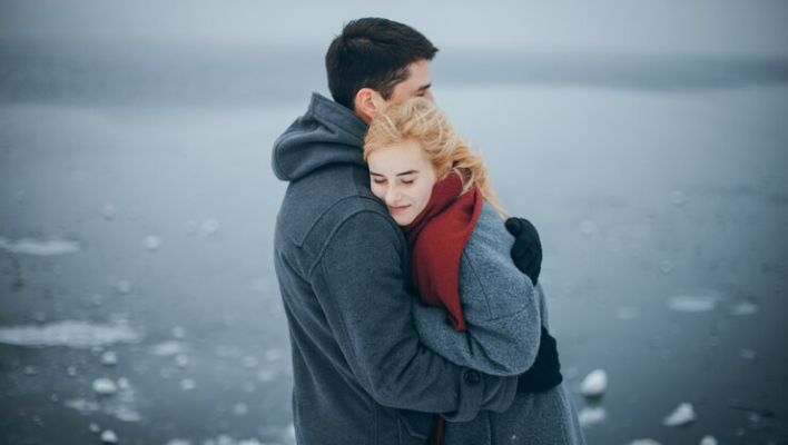 Couple embracing vulnerability and trust through conscious love and emotional presence.