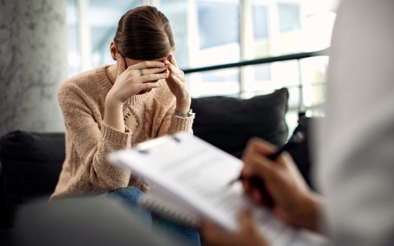 Depressed woman having psychotherapy session with doctor